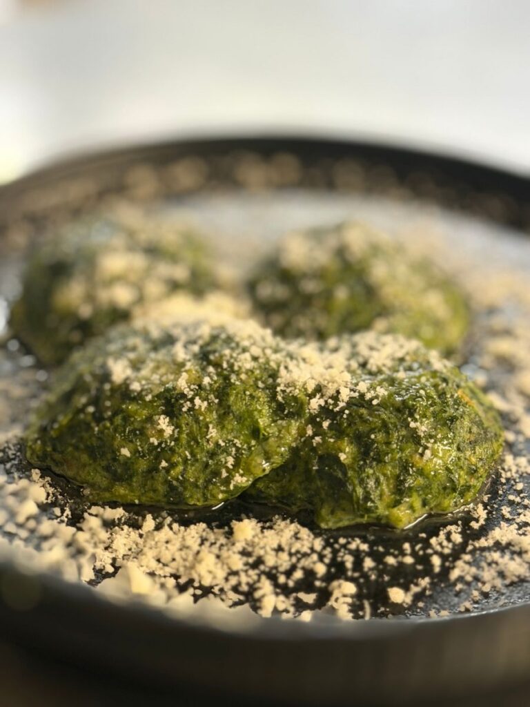 Gnudi toscani a base di formaggio Ravaggiolo del Casentino e spinaci spolverati con formaggio grattugiato