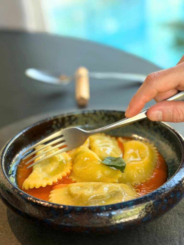 Piatto di pasta fresca ripiena a forma di mezzelune farcite con Ravaggiolo del Casentino e condite con salsa.
