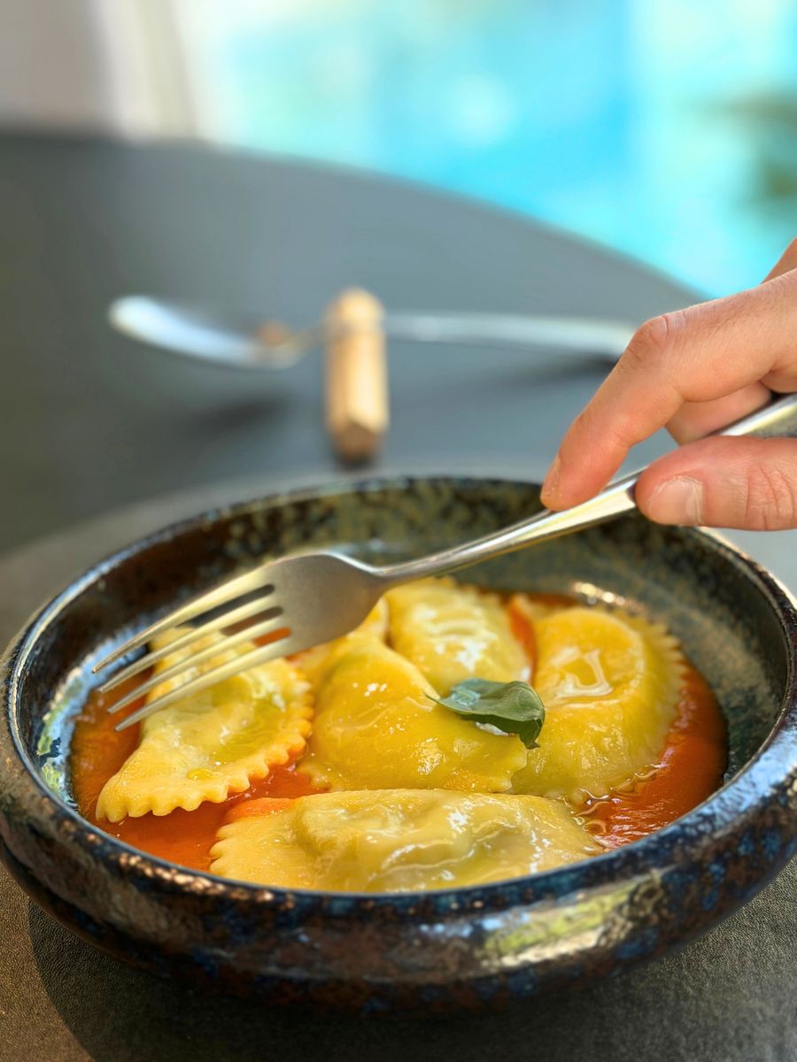Piatto di pasta fresca ripiena a forma di mezzelune farcite con Ravaggiolo del Casentino e condite con salsa.