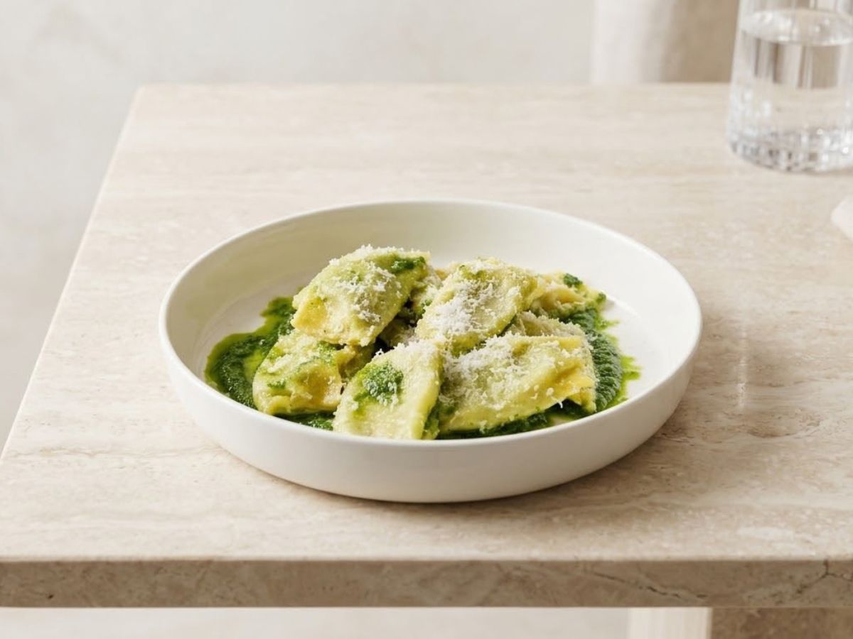 Piatto di ravioli fatti in casa conditi con salsa verde e formaggio grattugiato, specialità gastronomica casentinese.